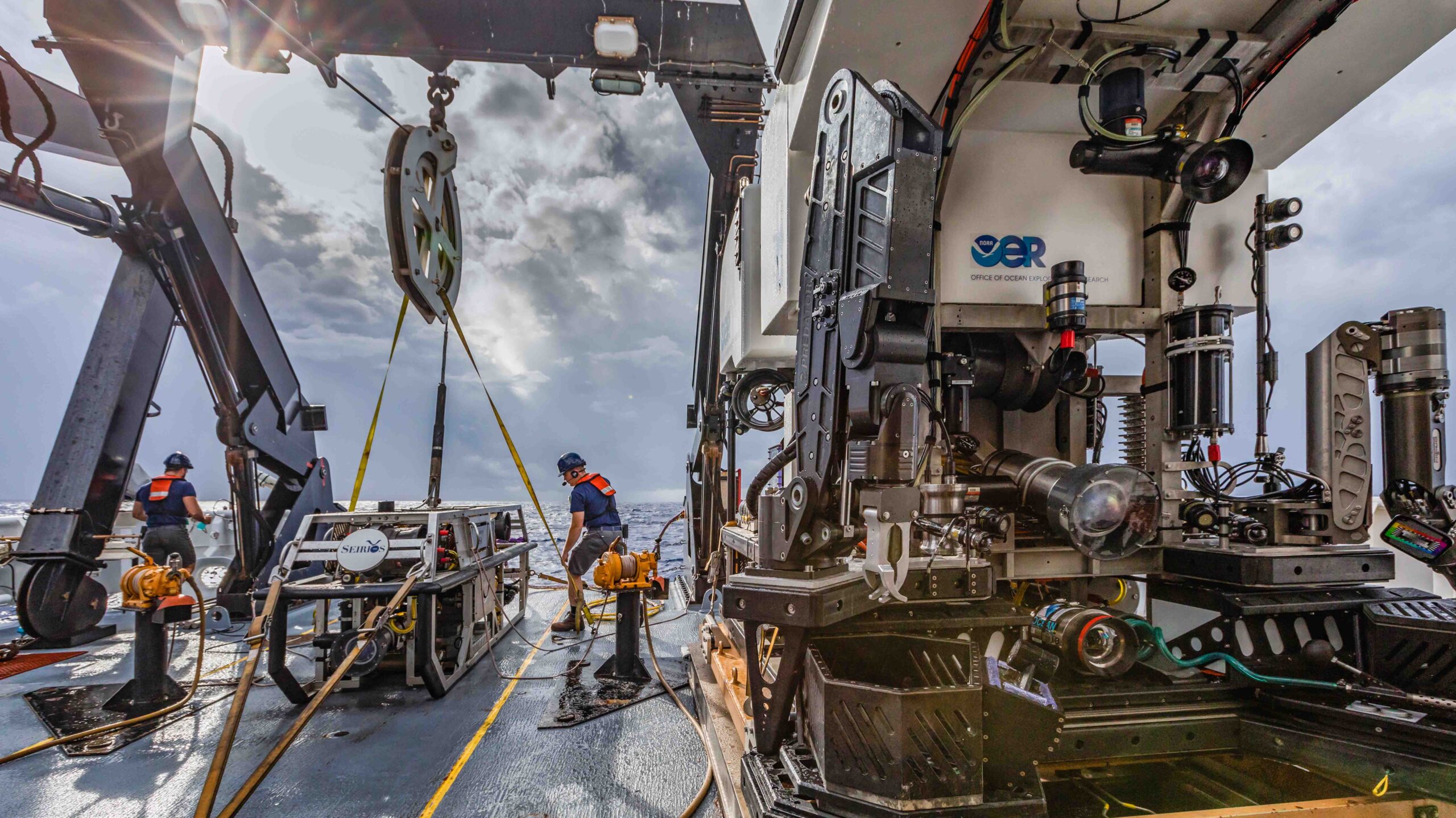 The team preps for the first remotely operated vehicle (ROV) dive of the mission on a cloudy morning.