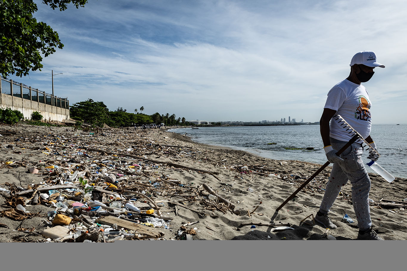 Man walking Playa Gringo beach during cleanup