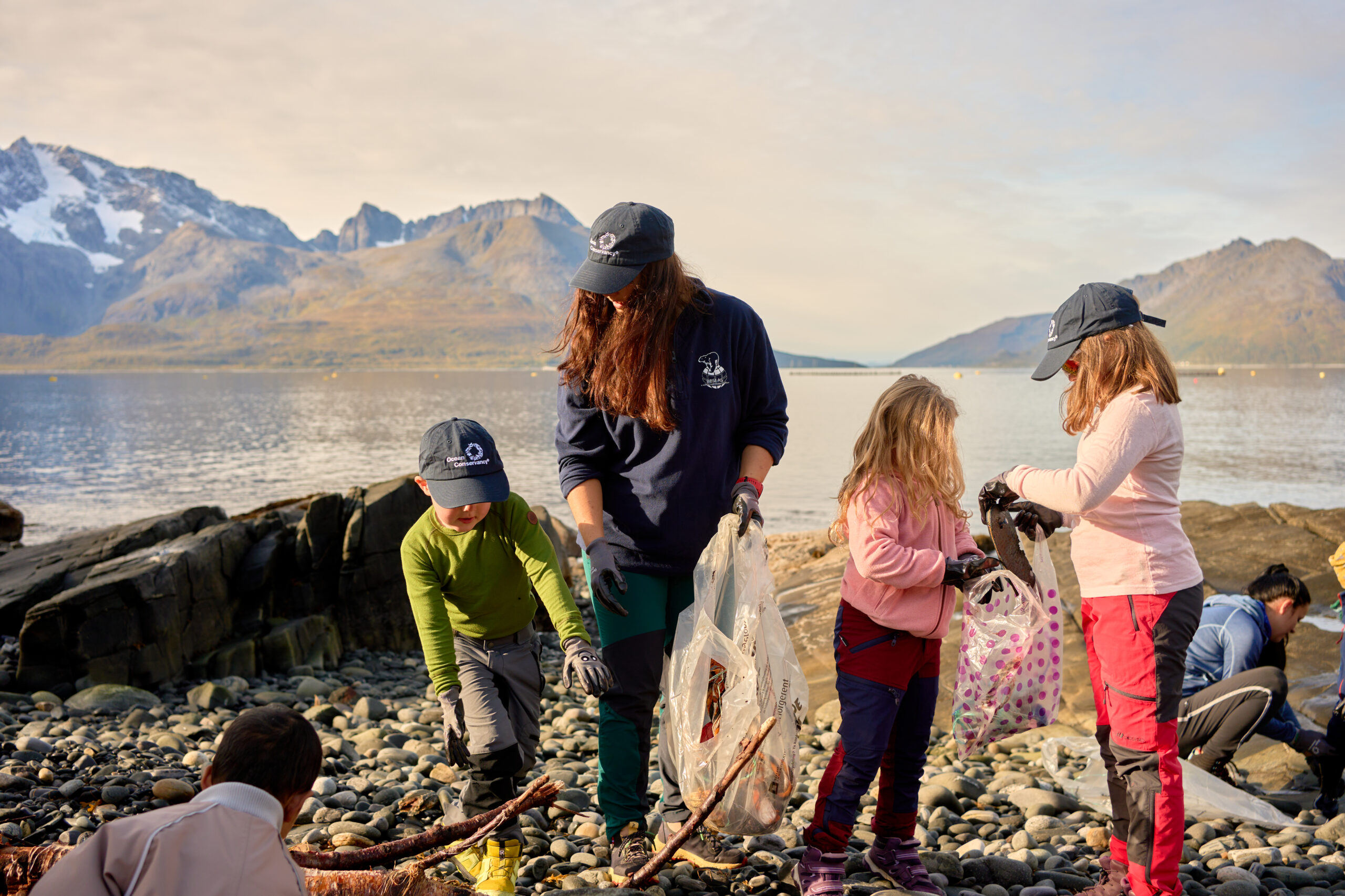 a family cleans trash off a beach in Norway